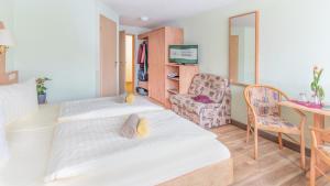 a room with two beds and a desk and a chair at Hotel Thüringenschanze in Oberhof