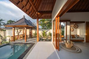 a house with a swimming pool and a gazebo at Dewi Kunti Villa in Tegalalang
