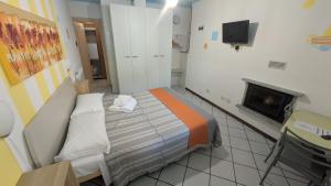 a small bedroom with a bed and a fireplace at Guesthouse Sofia in Stresa