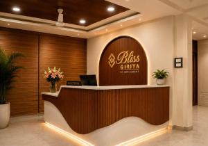 a hotel lobby with a reception desk with a sign at Bliss Giriya By Bergamont in Tiruvannāmalai
