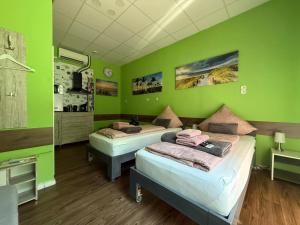 two beds in a room with green walls at Stern in Hückelhoven