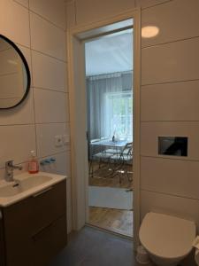 a bathroom with a toilet and a sink and a table at Lindens Bed&Breakfast in Mellerud