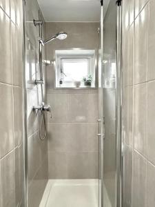 a bathroom with a shower with a glass door at Courtyard Oasis in London