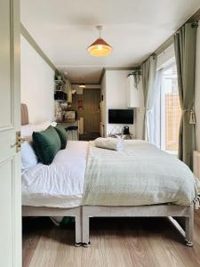 a bedroom with a large bed with green pillows at Courtyard Oasis in London