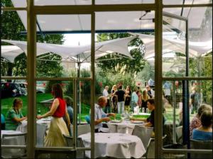 a group of people sitting at tables in a restaurant at Courtyard Oasis in London