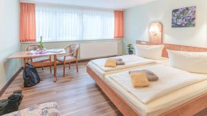 a hotel room with two beds and a table at Hotel Thüringenschanze in Oberhof +57 photos