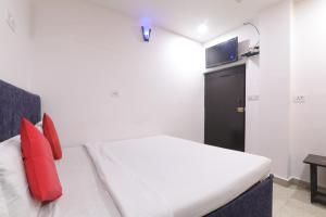 a bedroom with a bed with red pillows and a television at Simar Residency in Lucknow