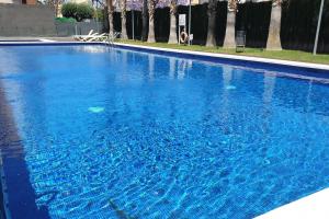 a large swimming pool with blue water at Apartamento de Lujo Cerca de la Playa EL CAMPELLO in El Campello