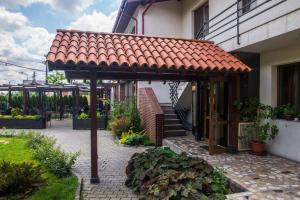 a pergola on the side of a house at Casa Vanatoreasca in Mogoşoaia