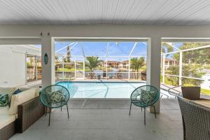 a swimming pool with two chairs and a couch at Waterfront Pool Game Room Gulf Access in Cape Coral
