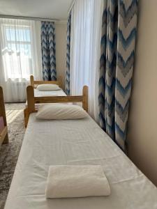 two twin beds in a room with a window at Kochkor valley in Kochkorka +1 photo