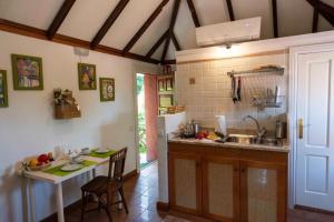 a kitchen with a sink and a table with chairs at Rincón de los Abanes - Finca Casa Jardín-VV in Las Lagunas +4 photos