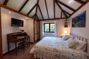 a bedroom with a bed and a desk at Rincón de los Abanes - Finca Casa Jardín-VV in Las Lagunas