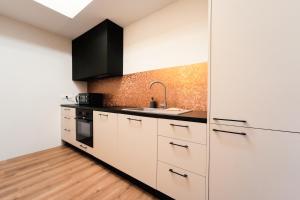 a kitchen with white cabinets and a sink at Apartament Kutno - Sami Swoi in Kutno