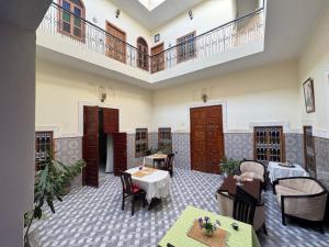 a restaurant with tables and chairs and a balcony at Riad Ba brahim in Rabat +43 photos