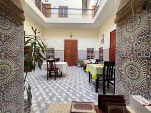 a living room with a table and chairs at Riad Ba brahim in Rabat
