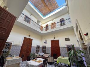 a dining room with tables and chairs and a skylight at Riad Ba brahim in Rabat