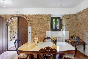 a dining room with a table and a stone wall at Fattoria San Pio in Naso +87 photos