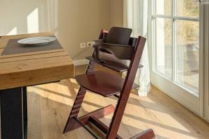 a wooden chair sitting next to a wooden table at Das Reethaus in Groß Schwansee