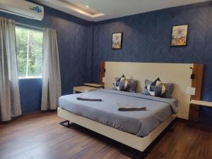 a bedroom with a large bed with blue walls at FabHotel Elite Residency in Vasai
