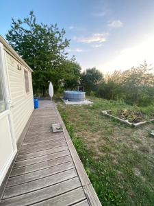 a wooden walkway next to a house with a yard at Romantisches Tiny House mit Pool and Air Condition in Tržec