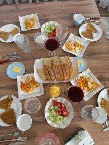 a wooden table with plates of food and glasses of wine at Kochkor valley in Kochkorka