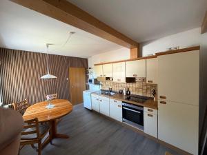 a kitchen with a wooden table and a table and a dining room at Haus Milan in Holzminden