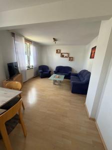 a living room with blue couches and a table at Haus Milan in Holzminden