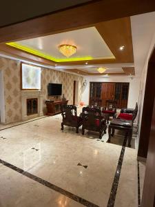 a large living room with chairs and a television at Queens Homestay in Trivandrum