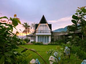 a house with a large window on a yard at Edy's Farm Cottage in Jabon