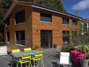 a table and chairs in front of a building at Effet Lodge in Saint-Cyr-au-Mont-dʼOr