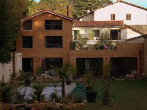 a house with a courtyard with trees and plants at Effet Lodge in Saint-Cyr-au-Mont-dʼOr