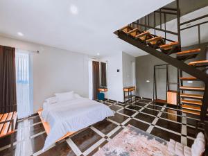 a bedroom with a bed and a spiral staircase at Edy's Farm Cottage in Jabon