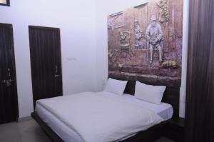a bedroom with a bed with a painting on the wall at Hotel Shaktideep in Pushkar +17 photos