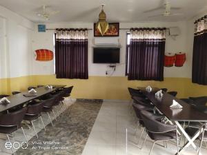 a conference room with tables and chairs and a flat screen tv at Hotel Shaktideep in Pushkar