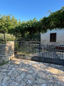 a fence in front of a house with trees at Casa Anima Allegra in Triban +7 photos