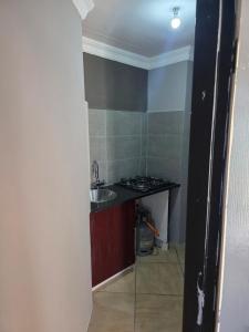 a small kitchen with a sink and a stove at The Good Samaritan 4 in eMalahleni