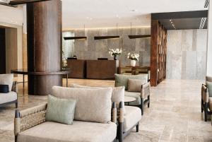 a lobby of a hotel with chairs and a reception at Chaonian Hotel in Dhërmi +35 photos
