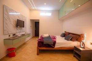 a bedroom with a bed and a television in it at Verdant Crestwood Nilgiris in Coonoor +38 photos