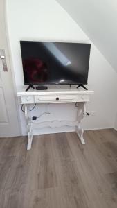 a white desk with a tv on top of it at Les tournesols in Woincourt