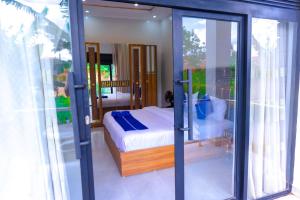 a bedroom with a bed and sliding glass doors at Zeus Boutique Apartment in Kigali