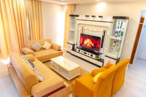 a living room with a fireplace and yellow furniture at Zeus Boutique Apartment in Kigali