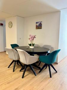 a dining room table with chairs and a vase with flowers at Garten-Apartment in Selm
