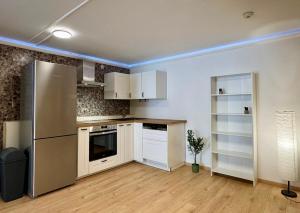 a kitchen with a stainless steel refrigerator and white cabinets at Garten-Apartment in Selm