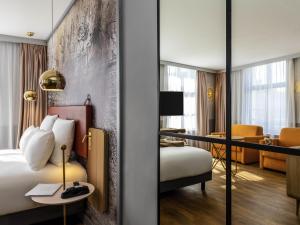 a hotel room with a bed and a desk at Mercure Saint Omer Centre Gare in Saint-Omer