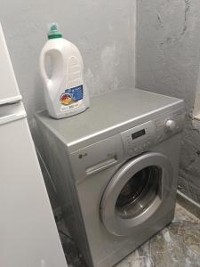 a washing machine with a bottle of detergent on top of it at Shios kari in Glola
