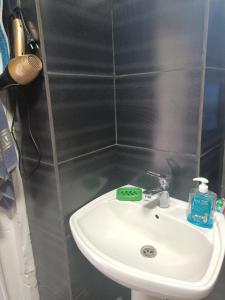 a bathroom with a white sink and a gray wall at Shios kari in Glola +15 photos