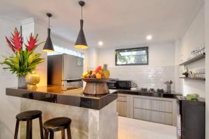 a kitchen with a counter with a bowl of fruit on it at Selasih Beach House in Seminyak