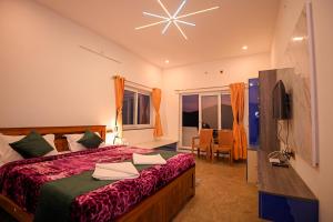 a bedroom with a bed and a television in it at Verdant Crestwood Nilgiris in Coonoor
