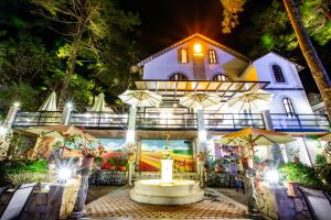 a house with a fountain in front of it at night at De Vivre Café & Home in Kon Plong
